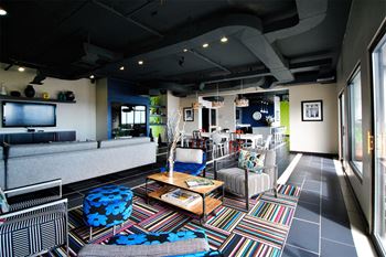 a lobby with couches and chairs and a tv